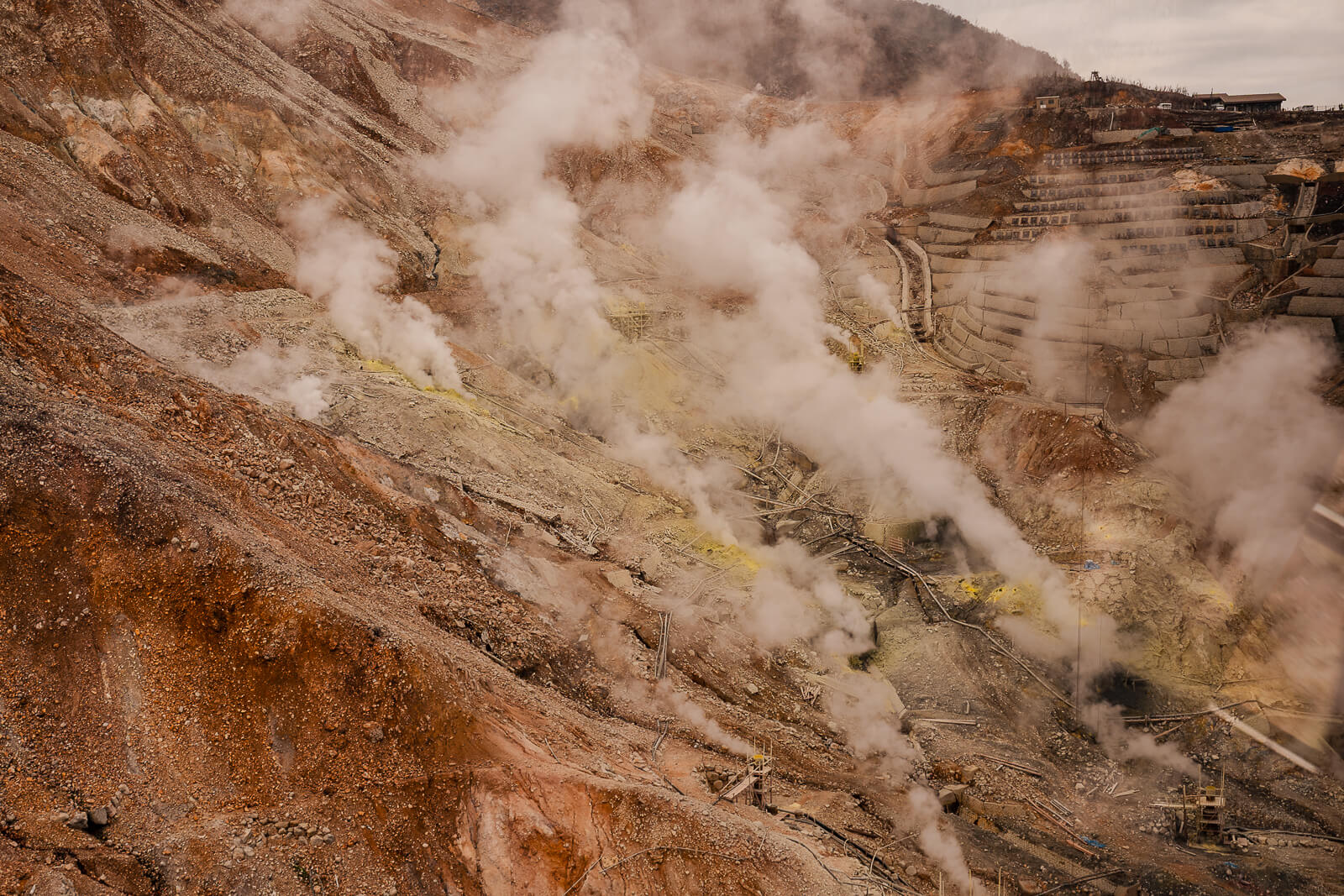 Compressed aerial view of dense steam rising across Owakudani slopes