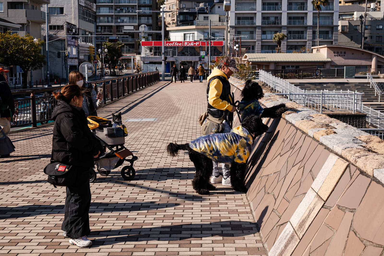 People walking along the promenade behind Atami Sun Beach