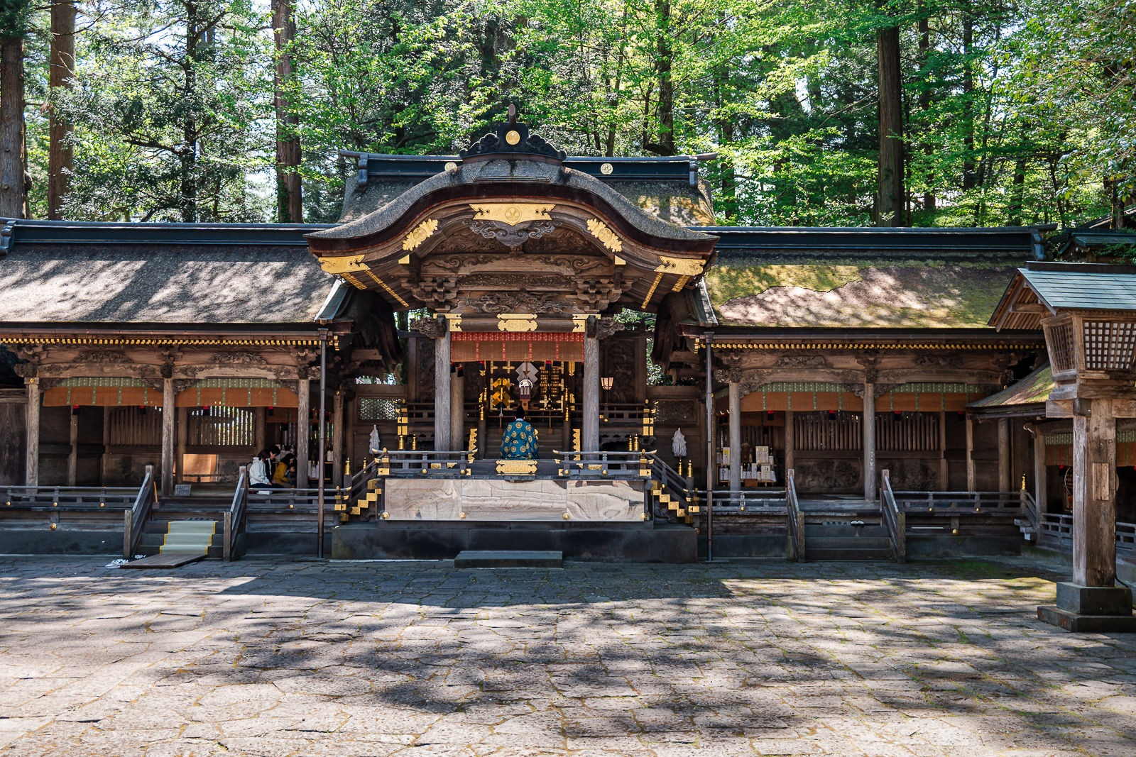 Open shrine grounds with visitors spread across space at Suwa Taisha Kamisha Honmiya, Suwa